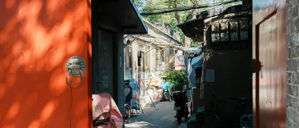 A narrow Beijing hutong lane with bicycles and laundry