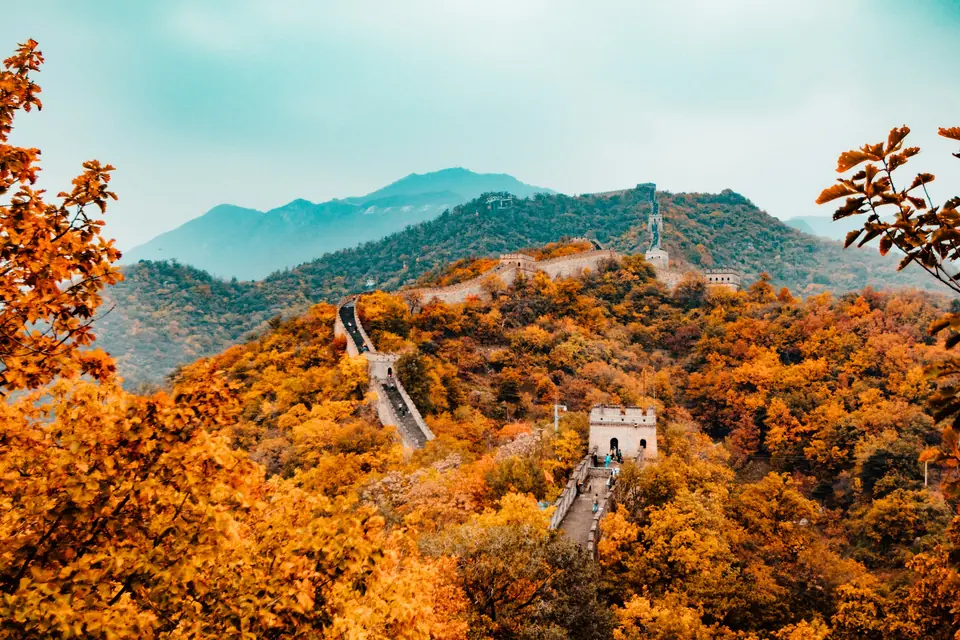 The Great Wall winding along a ridge through autumn trees near Beijing