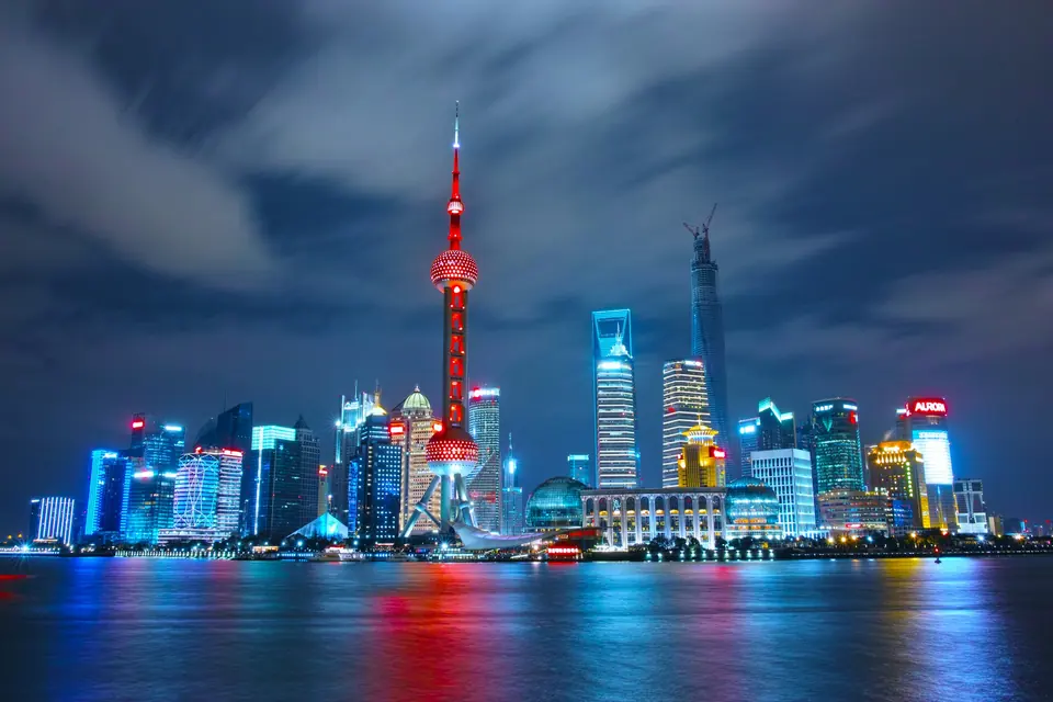 The Pudong skyline in Shanghai lit up at night across the Huangpu River